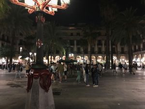 Nighttime view of Barcelona's Plaça Reial featuring one of the lampposts created by Gaudí