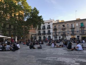 Young people lounging on the cement at Plaça del Sol